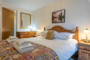 a bedroom with a large bed with towels on it at Torr Apartment Raven in Fort Augustus