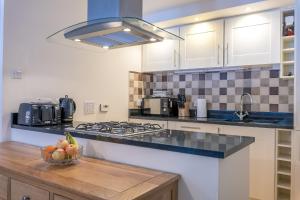 a kitchen with a bowl of fruit on a counter at Torr Apartment Raven in Fort Augustus +1 photo