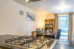a kitchen with a stove and a dining room at Torr Apartment Raven in Fort Augustus