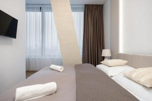 a hotel room with two beds with towels on them at Apollo One, 1BR Signature Residence in Nivy