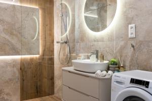 a bathroom with a sink and a washing machine at Apollo One, 1BR Signature Residence in Nivy