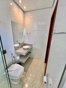a bathroom with a toilet and a sink and a mirror at Gran Vale Hotel in Guanhães +35 photos