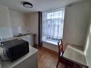 a small kitchen with a television and a window at The Albert Hotel in Gloucester