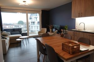 a kitchen and living room with a table and chairs at Madison A in Westende