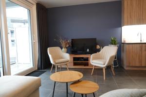 a living room with two chairs and a tv at Madison A in Westende