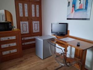 a room with a desk with a television and a refrigerator at The Albert Hotel in Gloucester +78 photos