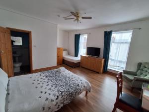 a bedroom with a bed and a couch and windows at The Albert Hotel in Gloucester