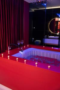 a red bath tub with two glasses of wine at Luxury Love Suites in Elbasan
