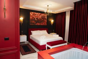 a red bedroom with a bed and a bath tub at Luxury Love Suites in Elbasan +41 photos
