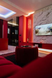 a living room with a red couch and a tv at Luxury Love Suites in Elbasan