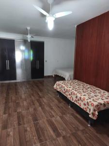a bedroom with a bed and a wooden floor at Casa Bilbao in Maricá