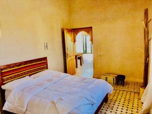 a bedroom with a bed and an open door at Charmante Villa Traditionnelle in Marrakesh