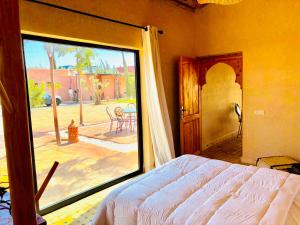 a bedroom with a bed and a large sliding glass door at Charmante Villa Traditionnelle in Marrakesh