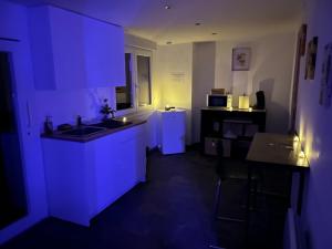 a kitchen with blue lighting in a dark room at Evad&vous in Recquignies +3 photos