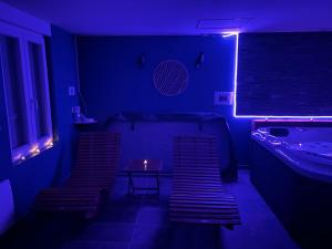 a dark room with two chairs and a tub at Evad&vous in Recquignies