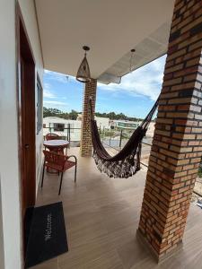 a porch with a hammock and a table and chairs at Pousada Boi de Axixá in Barreirinhas