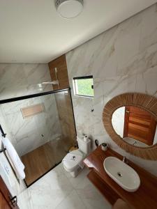 a bathroom with a toilet and a sink and a mirror at Pousada Boi de Axixá in Barreirinhas