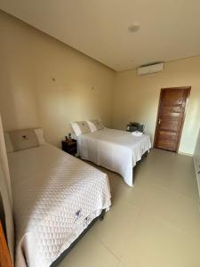 a hotel room with two beds and a window at Pousada Boi de Axixá in Barreirinhas
