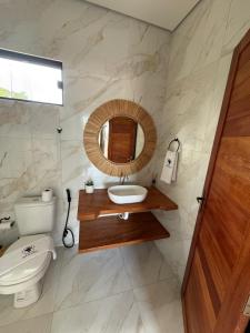 a bathroom with a toilet and a sink and a mirror at Pousada Boi de Axixá in Barreirinhas