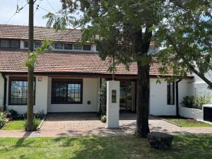 a house with a tree in front of it at Costanera 61, frente a la laguna in Chascomús