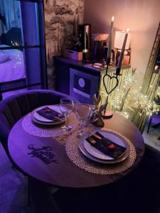 a table with two plates and wine glasses on it at la chambre d'hôte de glad et guigui in Rinxent