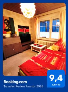 a bedroom with a red bed and a tv at Hakuna Matata - Gemütlichkeit bei Oldenburg in Hatten