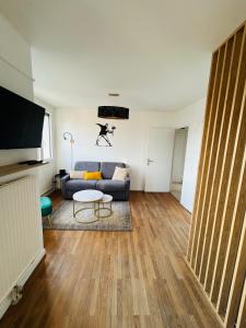 a living room with a couch and a table at Appartement Bellevue - T2 vue montagne - calme - parking gratuit - 4 personnes in Meylan