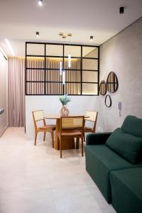 a living room with a green couch and a table at Apartamento Loft 02 Lazer Completo in Belo Horizonte