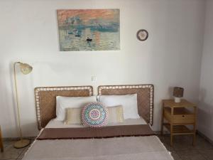 a bedroom with a bed with a picture on the wall at MARIA 'S LITTLE HOUSE in Patitiri
