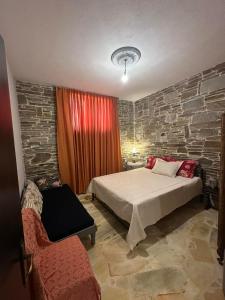 a bedroom with a bed and a brick wall at Thodis villa's in Karianí
