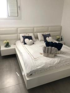 a white bed with blue and white pillows on it at Apartment with private pool in Ashkelon +14 photos
