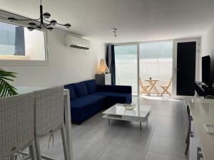 a living room with a blue couch and a table at Apartment with private pool in Ashkelon