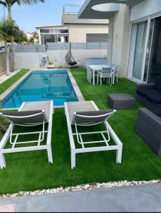 two chairs and a table and a swimming pool at Apartment with private pool in Ashkelon