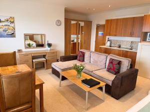 a living room with a couch and a kitchen at Porthole Suites in Saint Aubin