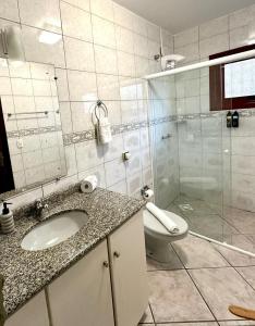 a bathroom with a sink and a toilet and a shower at Pousada Cores De Outono in Canela +24 photos