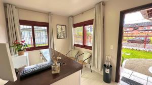 a room with a desk with a keyboard and windows at Pousada Cores De Outono in Canela