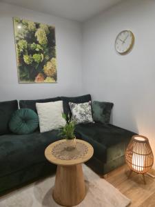 a living room with a black couch and a table at Hortensjowe Zacisze in Wolibórz