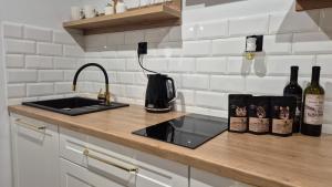 a kitchen counter with a sink and bottles of wine at Hortensjowe Zacisze in Wolibórz +53 photos