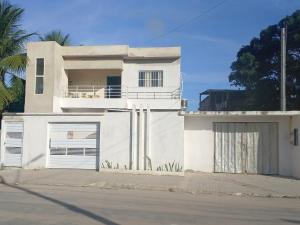 a white house with two garage doors on a street at Casa Sol in Cabo de Santo Agostinho