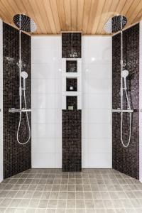a bathroom with two showers and a tiled wall at Villa Bear Den in Kittilä +46 photos