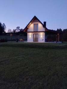 a house with lights on the side of a field at Domek Na Klinie in Jastrzębia
