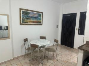 a table and chairs in a room with a picture on the wall at Kitnet no interior de São Paulo 22 in Serra Negra +3 photos