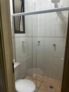a bathroom with a glass shower with a toilet at Kitnet no interior de São Paulo 22 in Serra Negra