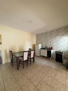 a kitchen with a table and chairs and a refrigerator at Casa para 5 pessoas, 1 vaga de garagem, wi-fi, próximo EMS in Hortolândia