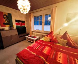 a bedroom with a red bed and a television at Hakuna Matata - Gemütlichkeit bei Oldenburg in Hatten