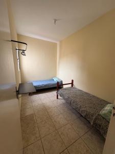 a room with two beds and a tiled floor at Casa para 5 pessoas, 1 vaga de garagem, wi-fi, próximo EMS in Hortolândia