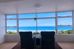 a dining room with a table and a view of the ocean at 32 Warnadoone- On Warner beach-Amanzimtoti in Kingsborough