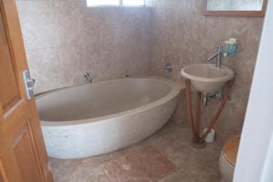 a bathroom with a large tub and a sink at 32 Warnadoone- On Warner beach-Amanzimtoti in Kingsborough +40 photos