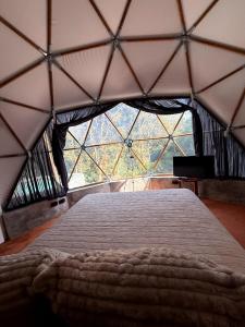 a bedroom with a large window in a tent at Alma Glamping in Xalapa +12 photos