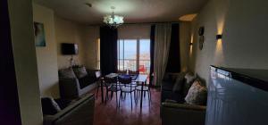 a living room with a couch and a table with chairs at Porto Sokhna Pyramids - For Families Only vip in Ain Sokhna